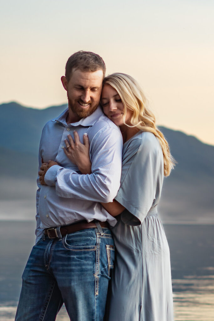 Engaged couple embracing at Lake McDonald