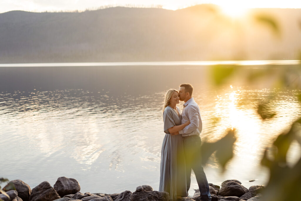 Amy and Spencer celebrating their engagement on the beach at Lake McDonald, GNP.