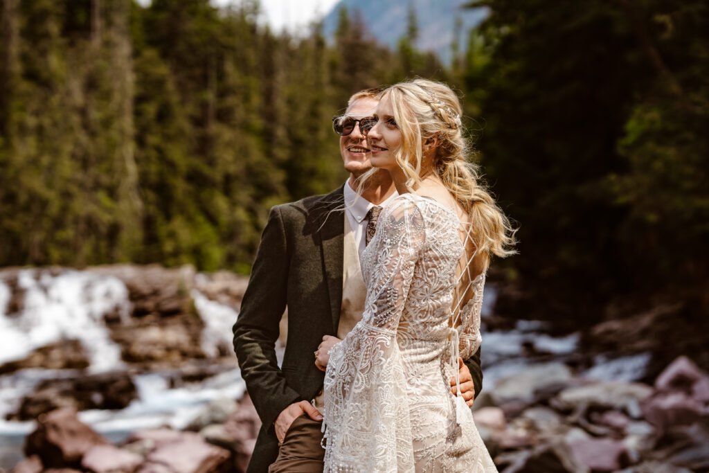 Bride and groom on river bank. 