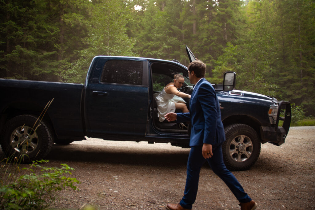 groom getting his bride out of the truck for their elopement