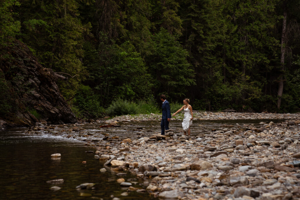 couple in a remote location crossing a river